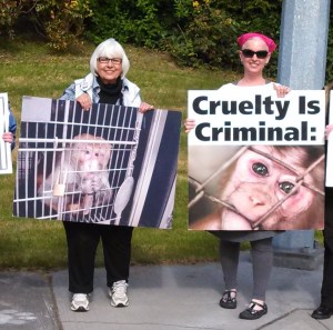 Claudine Erlandson (left) and Amy Webster protest outside the SNBL in Everett.